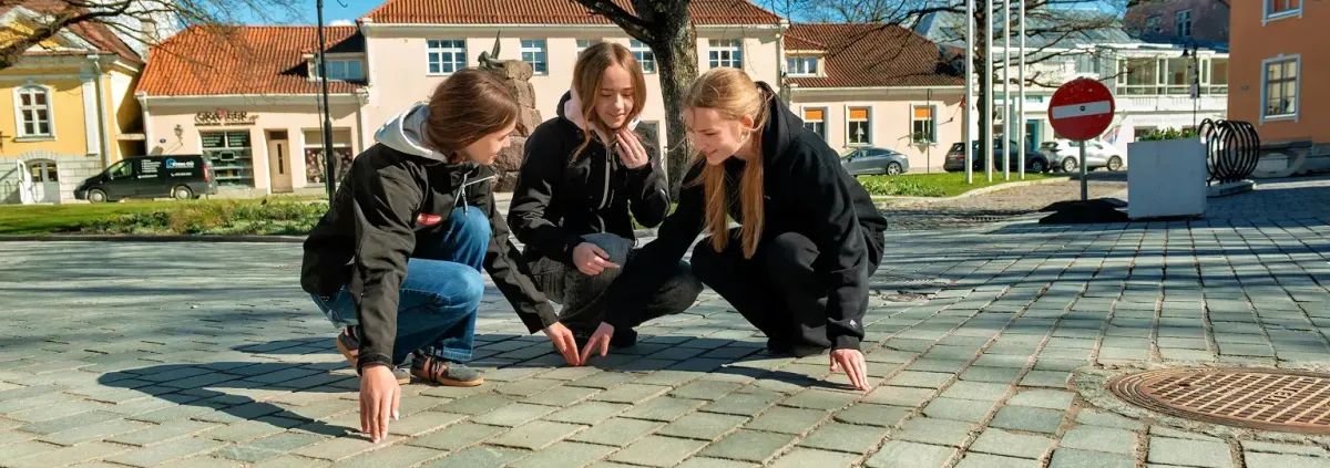 Children in a town square counting cobble stones